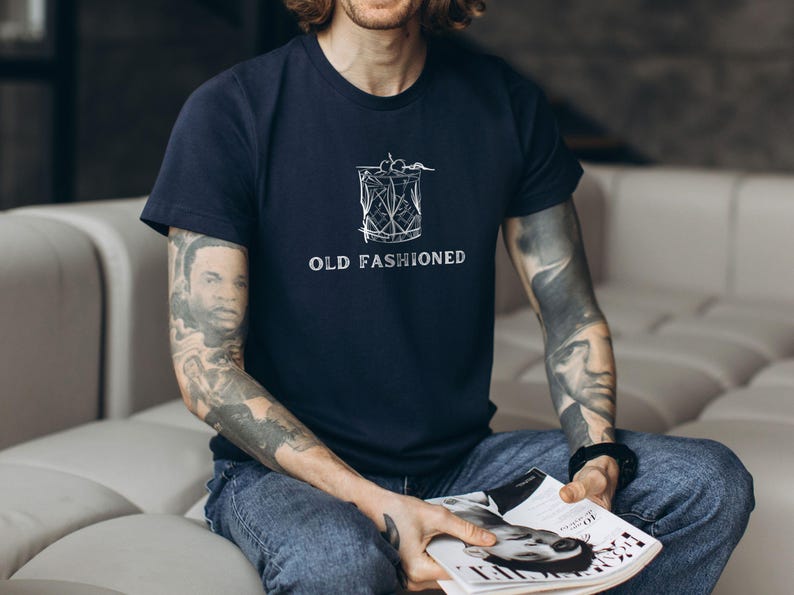 May include: A navy blue t-shirt with a white graphic of a cocktail glass and the text "OLD FASHIONED".