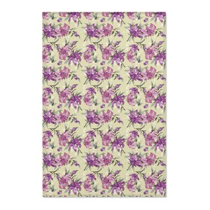 May include: A yellow fabric with a repeating pattern of purple flowers. The flowers have a light purple center and dark purple petals.
