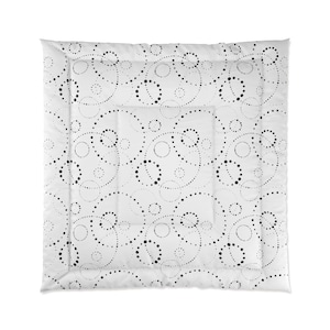 May include: White duvet cover with a black and white pattern of circles and dots. The pattern is repeated throughout the duvet cover.