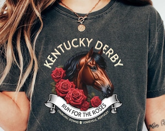 May include: A dark gray t-shirt with a graphic of a brown horse with a red rose wreath and the text "Kentucky Derby Run for the Roses Churchill Downs Louisville, Kentucky".