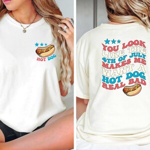 Puede incluir: Camiseta blanca con un gr&aacute;fico de hot dog y el texto "HOT DOG" en la parte delantera. La parte posterior de la camiseta tiene el texto "YOU LOOK LIKE THE 4TH OF JULY MAKES ME WANT A HOT DOG REAL BAD" con un gr&aacute;fico de hot dog.