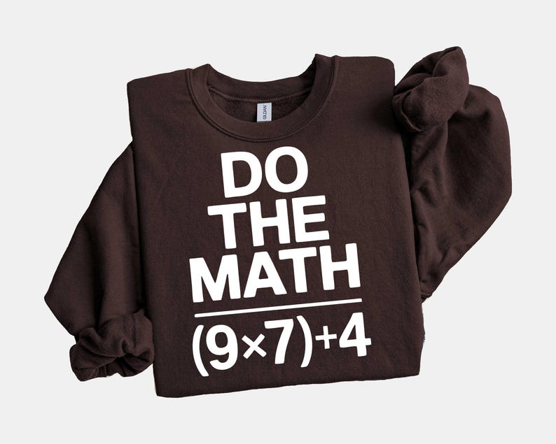 May include: A dark brown sweatshirt with the phrase "DO THE MATH" in large white block letters. Below the text is the equation (9x7)+4. The sweatshirt has a crew neck and long sleeves.