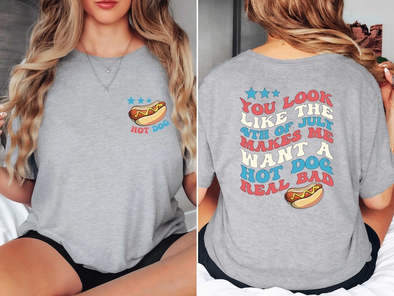Puede incluir: Camiseta gris con un gr&aacute;fico de un hot dog en la parte delantera y el texto "You look like the 4th of July makes me want a hot dog real bad" en la parte posterior.