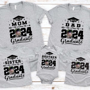Puede incluir: Un conjunto de camisetas grises y un body para beb&eacute; con dise&ntilde;os de graduaci&oacute;n. Cada prenda muestra el texto "Proud Mom", "Proud Dad", "Proud Sister", "Proud Brother" o "Graduate", el a&ntilde;o "2024" y una foto.