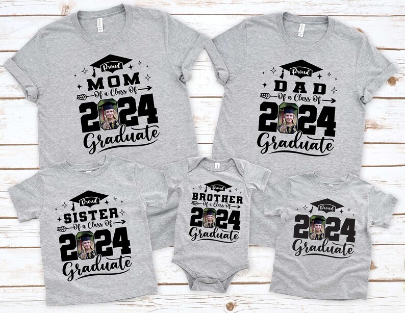 Puede incluir: Un conjunto de camisetas grises y un body para beb&eacute; con dise&ntilde;os de graduaci&oacute;n. Cada prenda muestra el texto "Proud Mom", "Proud Dad", "Proud Sister", "Proud Brother" o "Graduate", el a&ntilde;o "2024" y una foto.