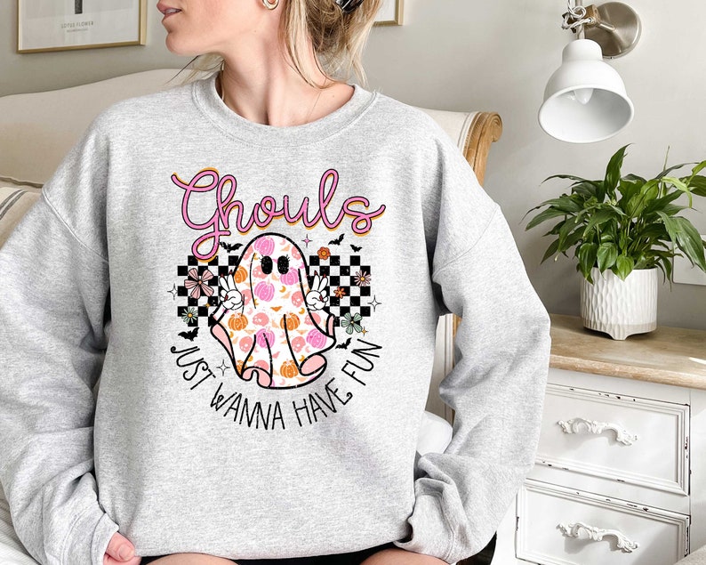 May include: A gray sweatshirt with a pink and orange ghost graphic and the text "Ghouls Just Wanna Have Fun".