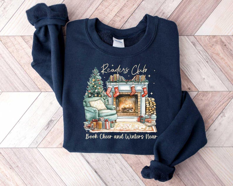 K&ouml;nnte beinhalten: Navyblauer Sweatshirt mit einem weihnachtlichen Design mit einem Kamin, einem Weihnachtsbaum und dem Text "Readers Club Book Cheer and Winters Near".