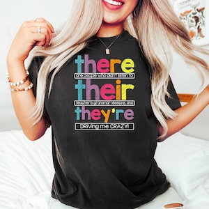 Puede incluir: Camiseta negra con la frase "there are people who didn't listen to their teacher's grammar lessons, and they're driving me CRAZY!" en varios colores y fuentes.