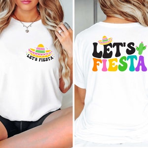 May include: White t-shirt with "Let's Fiesta" text in rainbow colors and a cactus graphic on the back. The front of the shirt features a sombrero graphic with the same text in black.