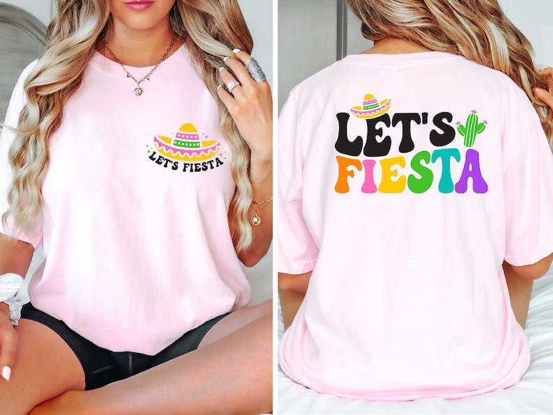 May include: Pink t-shirt with a small sombrero and the text "Let's Fiesta" on the front. The back of the shirt has the text "Let's Fiesta" in rainbow colors with a green cactus.
