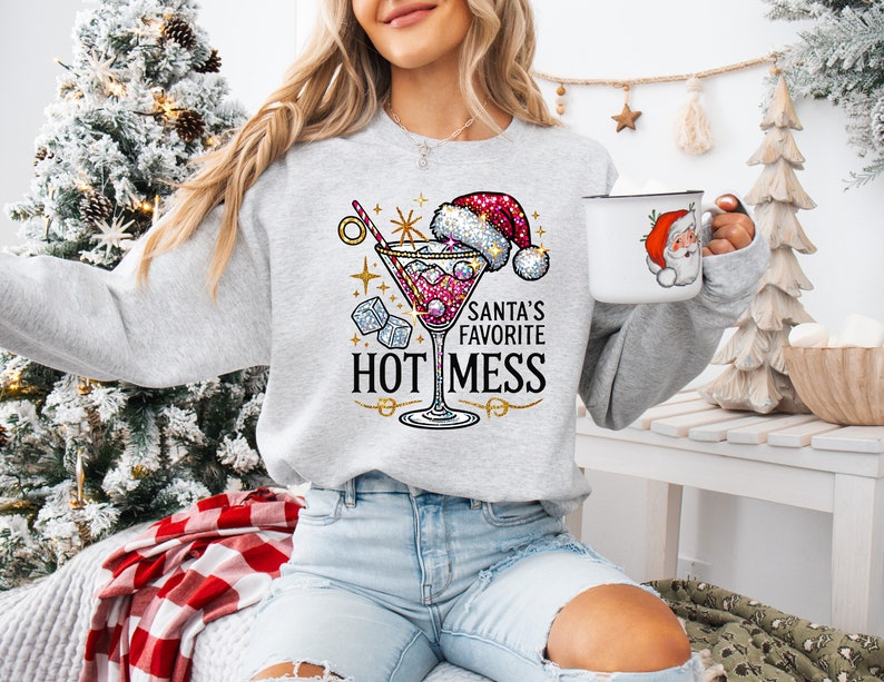 May include: A gray sweatshirt with a glittery martini glass design and the text "Santa's Favorite Hot Mess".