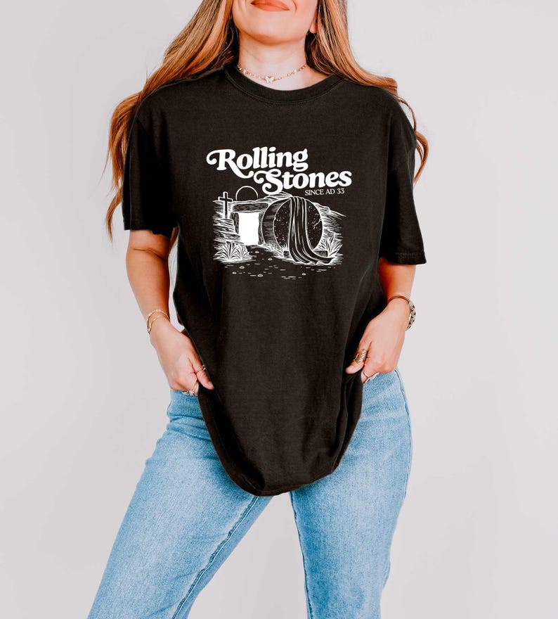 May include: Black t-shirt with a white graphic of a tombstone with the text "Rolling Stones Since AD 33".