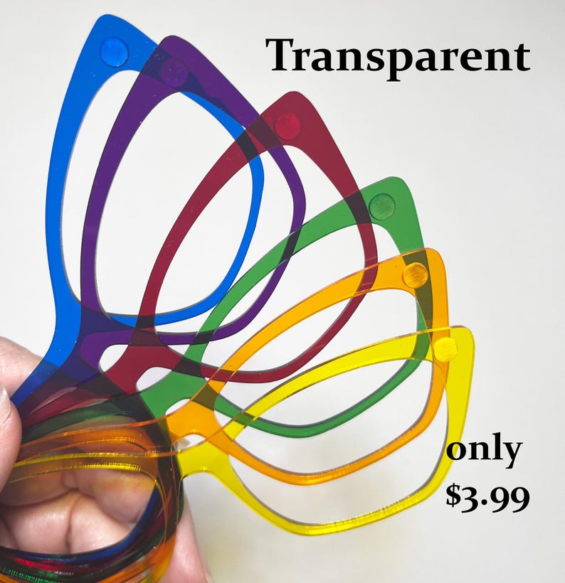 May include: A hand holds a stack of transparent, colorful eyeglasses frames. The frames are in shades of blue, purple, red, green, orange, and yellow. The word "Transparent" is written in black text at the top of the image.