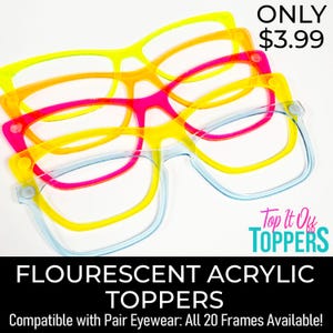 May include: A stack of colorful, fluorescent acrylic eyewear toppers in yellow, orange, pink, and blue. The toppers are designed to fit over existing eyewear frames. The image includes the text "FLOURESCENT ACRYLIC TOPPERS".