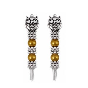 May include: Two silver-toned metal accessories, each featuring an owl design at the top. The stems are adorned with alternating gold-colored beads and silver-colored bead clusters. The accessories have a tapered, pointed end.