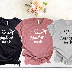 May include: Three t-shirts with the text "Airplane mode" and a heart with a plane flying through it. The shirts are black, pink, and gray.