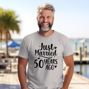 May include: A grey t-shirt with black text that reads "Just Married 50 Years Ago" with hearts and stars around the text.
