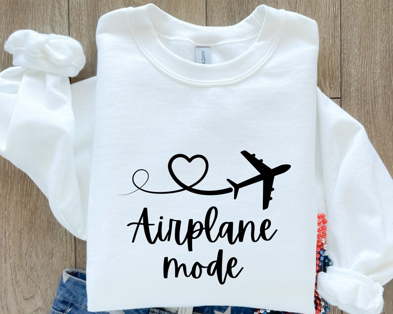 May include: White sweatshirt with a black airplane and heart design. The text "Airplane mode" is printed below the design.