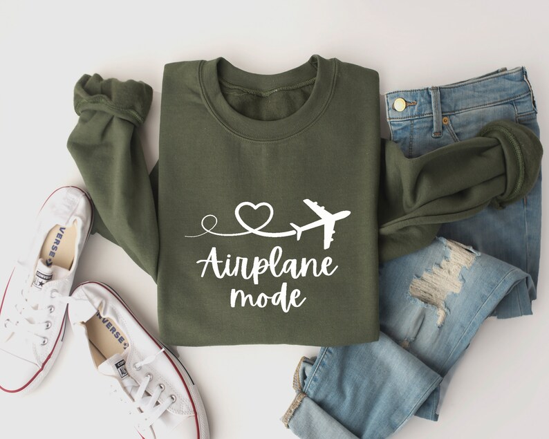May include: Green sweatshirt with white text that says "Airplane mode" and a small airplane and heart graphic.