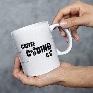 K&ouml;nnte beinhalten: Wei&szlig;e Keramik-Kaffeetasse mit schwarzem Text, der "Coffee Coding C++" lautet, wobei die Buchstaben "o" im Wort "Coding" durch Kaffeekirschen-Symbole ersetzt werden.