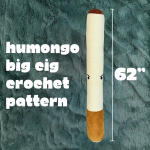 Pode incluir: Um cigarro de crochê branco grande com uma ponta marrom. O cigarro tem 157 cm de comprimento e tem um rosto de desenho animado com sobrancelhas zangadas.