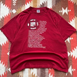 Peut inclure: T-shirt rouge avec l'inscription "THINGS THAT SOUND DIRTY IN FIREFIGHTING" et une liste de phrases liées aux pompiers. Le t-shirt a un col rond et des manches courtes. Le texte est en blanc.