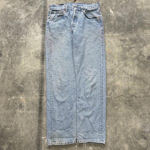 Op de afbeelding: Lichtblauwe denim jeans met een knoopsluiting, vijf-zakken ontwerp en een vervaagde wassing. De jeans hebben een rechte pijp en vertonen tekenen van slijtage.