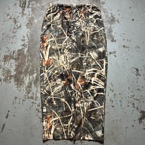 May include: Camouflage print skirt with a drawstring waist. The skirt is made of a lightweight fabric and has a relaxed fit.