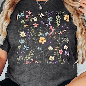 May include: A dark grey t-shirt with a floral print featuring a variety of colorful flowers and leaves.