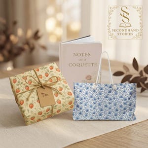 May include: A gift wrapped in paper with a strawberry pattern, tied with twine and a tag that says "To:". A book titled "Notes of a Coquette" and a blue floral patterned gift bag are also present.