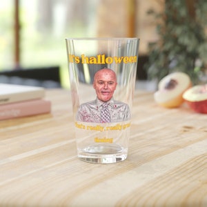 May include: A clear glass with a graphic of a man with blood splatters on his shirt. The text "It's halloween that's really, really great timing" is printed on the glass.
