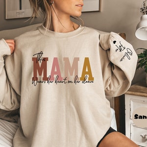 Custom This Mama Wears Her Heart On Her Sleeve Hoodie, Personalized Mom Sweatshirt With Kids Names, Cute Momma Outfit, Mothers Day Gifts