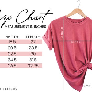 Puede incluir: Tabla de tallas para una camiseta en varios tama&ntilde;os, que muestra las medidas de ancho y largo en pulgadas. La tabla est&aacute; etiquetada como "Size Chart" y "Measurement in Inches". La camiseta se muestra en color carmes&iacute;.