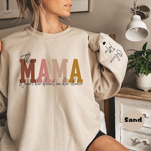 Custom This Mama Wears Her Heart On Her Sleeve Hoodie, Personalized Mom Sweatshirt With Kids Names, Cute Momma Outfit, Mothers Day Gifts