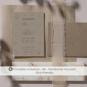 Könnte beinhalten: Eine beige Einladungskarte mit Muschelbildern, einem passenden Umschlag und einem dekorativen Band. Die Einladung enthält Ausfüllzeilen für den Namen des Empfängers, Veranstaltungsdetails und RSVP-Informationen. Der Text "Einladung" steht oben.