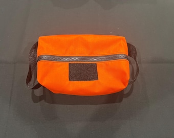 Neceser naranja con parche de regalo.
