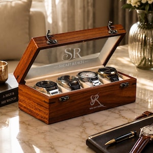 May include: A rectangular wooden watch box with a hinged glass lid featuring the engraved text SR SHAH RUKH. The box has four interior compartments, each holding a wristwatch. The front of the box displays the logo SR ROYAL CRAFT EXPEDITION.