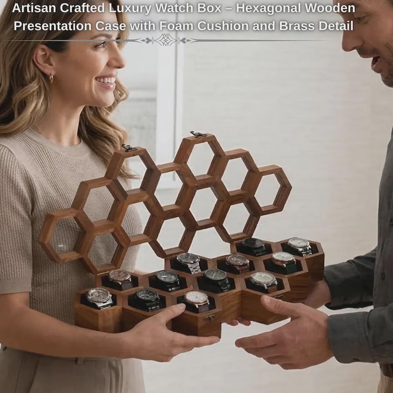 Puede incluir: Una caja hexagonal de madera para relojes con un marco en forma de panal y tapa abatible. El interior cuenta con compartimentos individuales, cada uno con un reloj sobre un coj&iacute;n de espuma. Incluye herrajes de lat&oacute;n y un panel superior transparente.