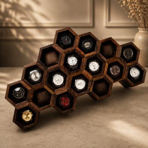 Puede incluir: Un expositor de relojes de madera marrón oscuro con una estructura de panal de varios compartimentos hexagonales. Varios relojes de pulsera con diversos colores de esfera y correas metálicas están colocados en los huecos.