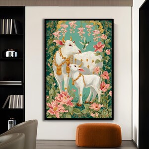 Puede incluir: Una impresi&oacute;n art&iacute;stica enmarcada que presenta una vaca y un ternero blancos adornados con joyas de oro, sobre un fondo de flores rosas y exuberante follaje verde. Tambi&eacute;n hay un colibr&iacute;. La obra de arte tiene un fondo turquesa.