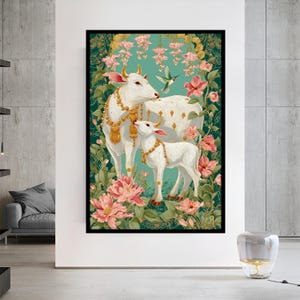 Puede incluir: Una impresi&oacute;n art&iacute;stica enmarcada que presenta dos vacas blancas adornadas con joyas de oro, sobre un fondo de flores rosas y exuberante vegetaci&oacute;n. Se ve un colibr&iacute;. La obra de arte tiene un fondo turquesa y un marco negro.