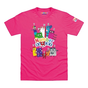 May include: A bright pink short-sleeved t-shirt featuring a colorful graphic of Numberblocks characters with the text Numberblocks in the center. The design includes various numbered block figures in different colors and shapes on the front.