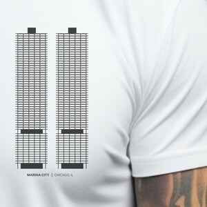 May include: White t-shirt with a black and white graphic of the Marina City towers in Chicago, Illinois. The text "MARINA CITY | CHICAGO, IL" is printed below the graphic.
