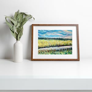 Peut inclure: Une peinture encadrée représentant un paysage avec un champ d'herbe haute et un ciel bleu avec des nuages blancs. L'herbe est un mélange de vert et de jaune, et il y a des fleurs blanches au premier plan.