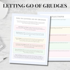 May include: Two sheets of paper with text about letting go of grudges. One sheet lists tips, including acknowledging feelings and practicing empathy. The other sheet has reflection questions. A white mouse, keyboard, and pen are in the background.