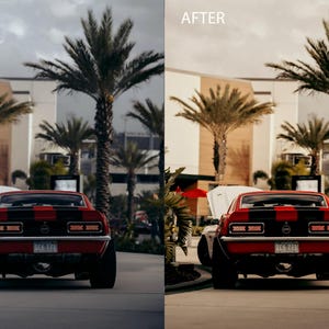 May include: A red classic car with a black stripe down the middle, parked in front of a building with palm trees. The car has a black bumper and black tail lights.
