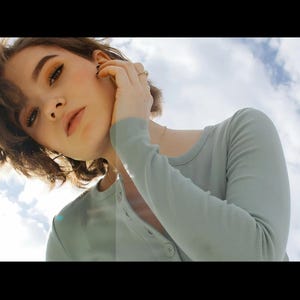 Puede incluir: Una persona con una camisa de manga larga verde claro con botones. La persona mira a la c&aacute;mara con un cielo nublado de fondo. La camisa tiene una textura acanalada.