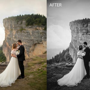 May include: A bride and groom are kissing in front of a large cliff. The bride is wearing a white wedding dress and the groom is wearing a black suit. The couple is standing on a grassy hilltop with a view of a forest in the background.