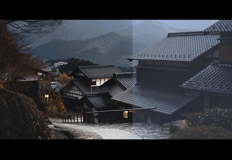 Puede incluir: Una vista panor&aacute;mica de casas tradicionales japonesas con tejados oscuros de tejas y paredes de color claro. Las casas est&aacute;n ubicadas en un valle con monta&ntilde;as al fondo, creando un paisaje sereno y pintoresco. La imagen fue tomada durante el d&iacute;a, con un cielo ligeramente nublado.