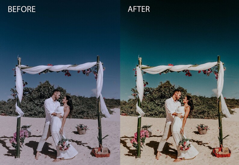 May include: A couple in white clothing stand under a white fabric canopy decorated with pink flowers, on a sandy beach. The couple is smiling and looking at each other. The sky is blue.